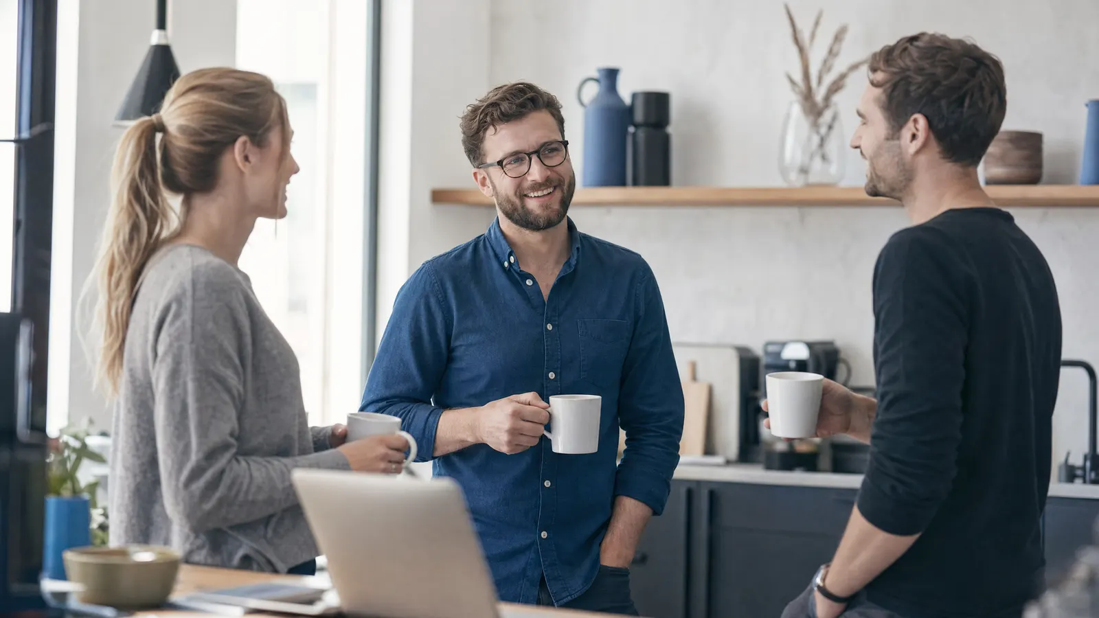 Kleines Team bespricht sich entspannt im Büro