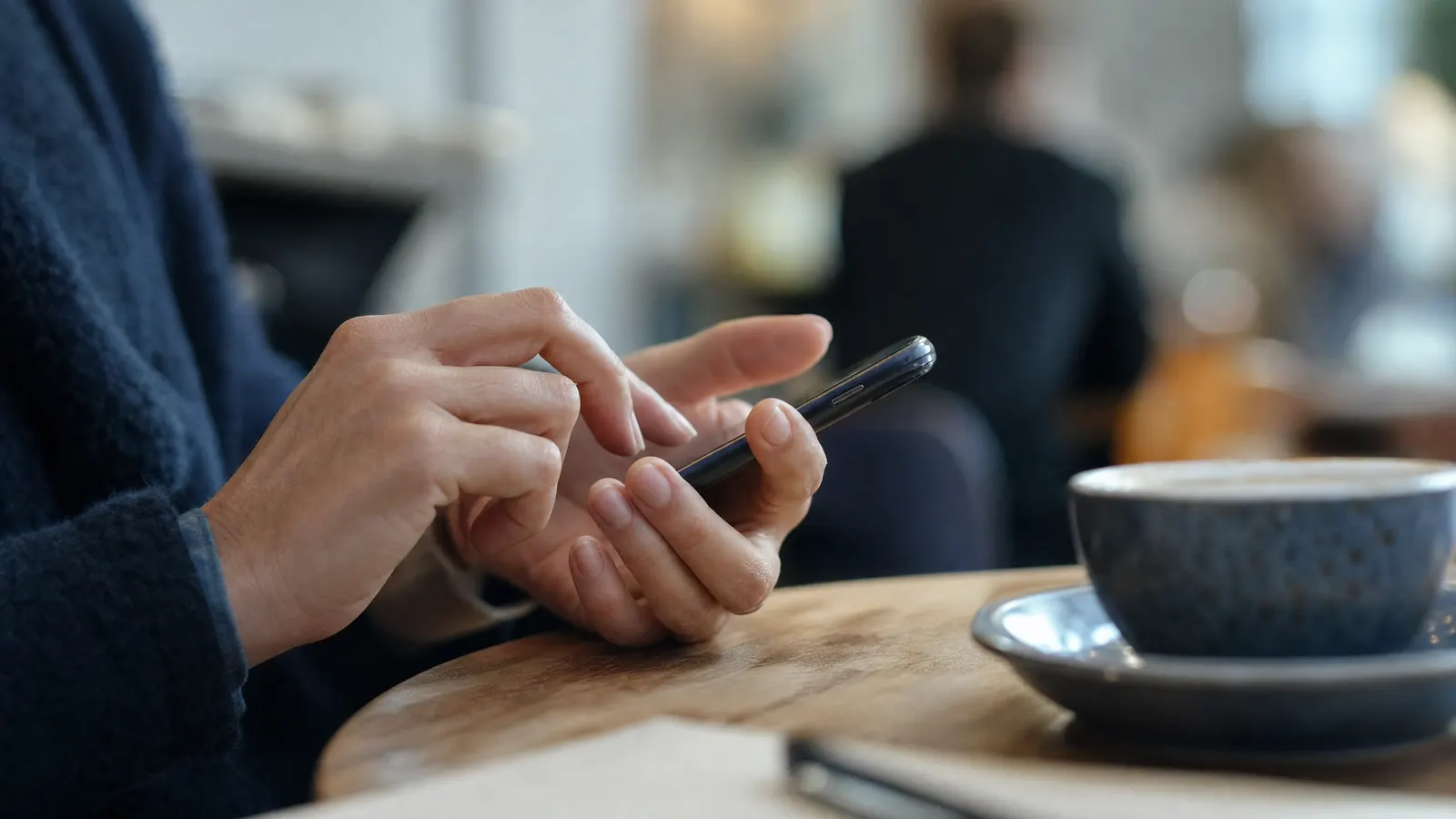 Hand tippt eine Nachricht auf dem Smartphone